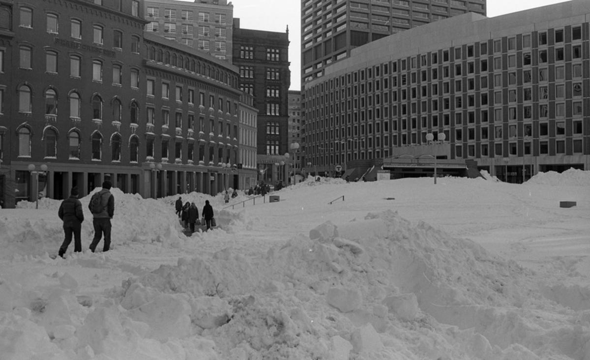 Snow piles and pedestrians in Boston City Hall Plaza