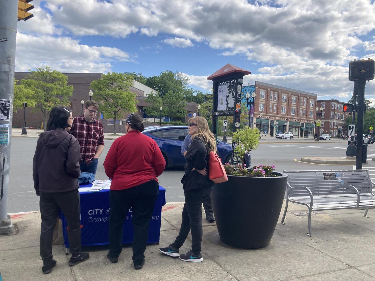 Group of people standing around a table in Union Square talking