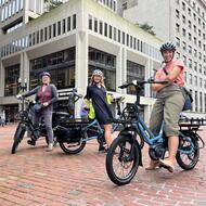 three people posing on e-bikes